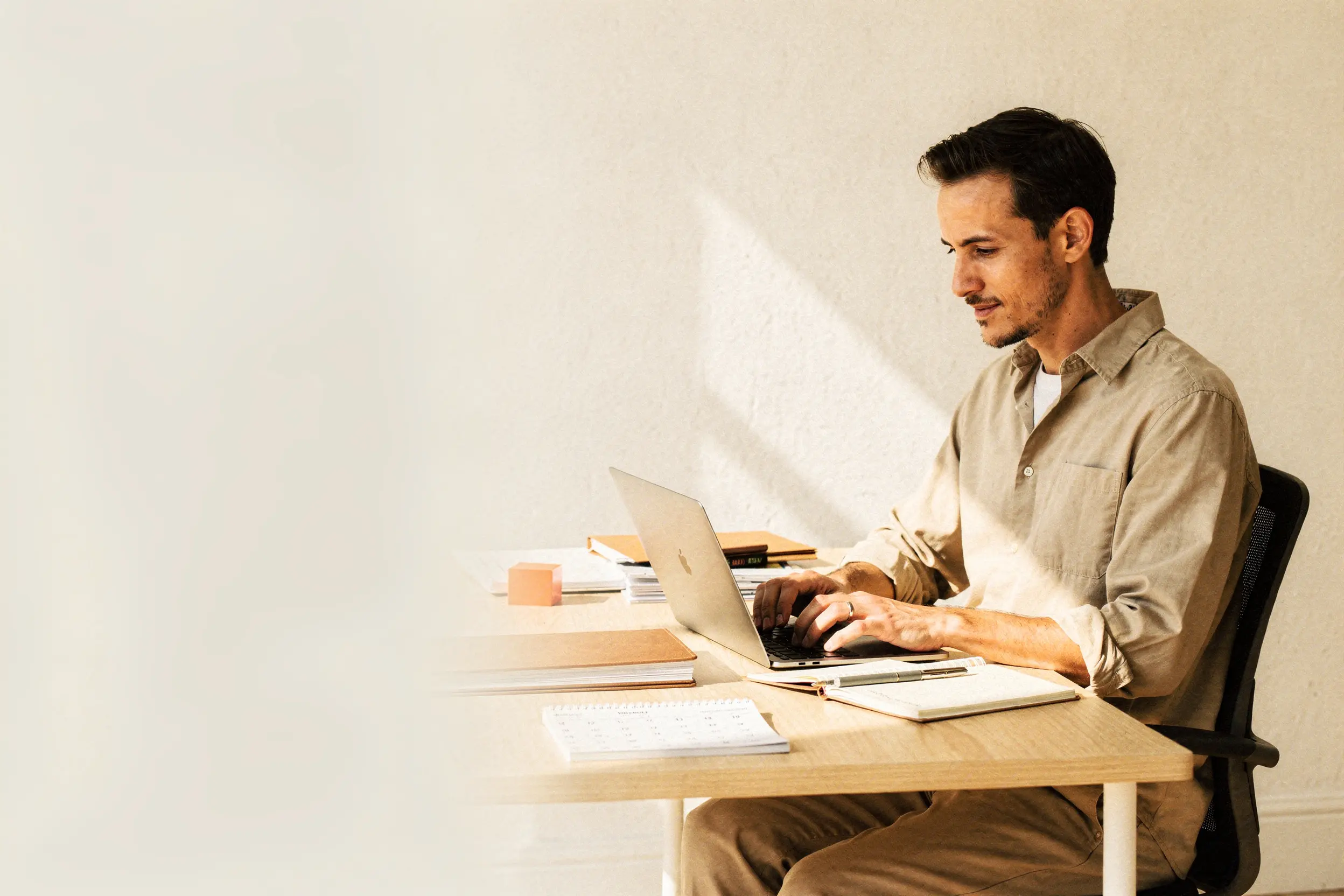 A small-business owner reviewing work at a bright studio desk